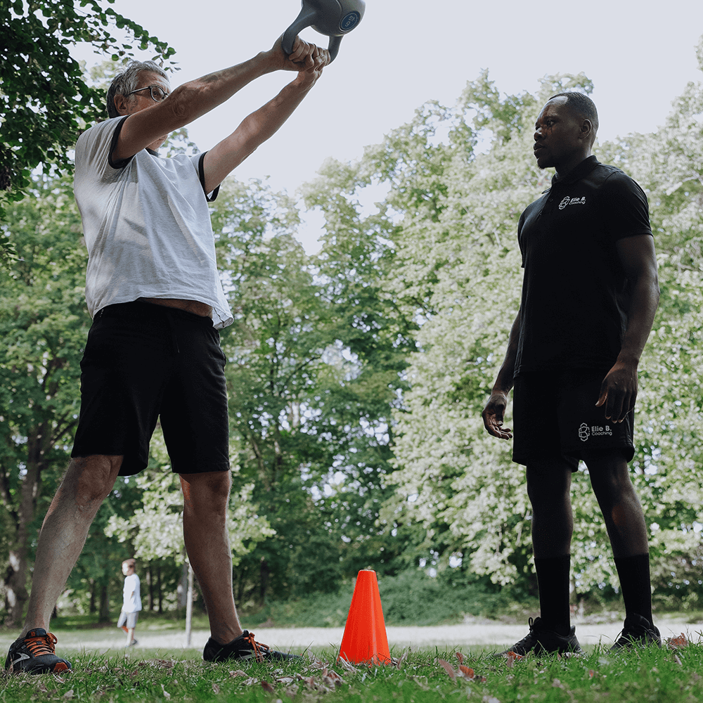 Coach sportif à Angers en plein air, entrainement avec un client utilisant des kettlebells