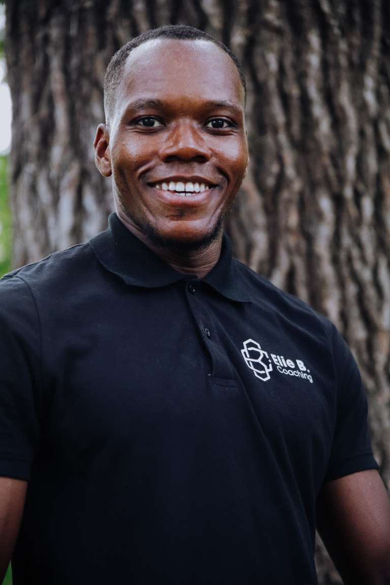 Élie B Coaching tout sourire en photo de portrait dans un parc à Angers