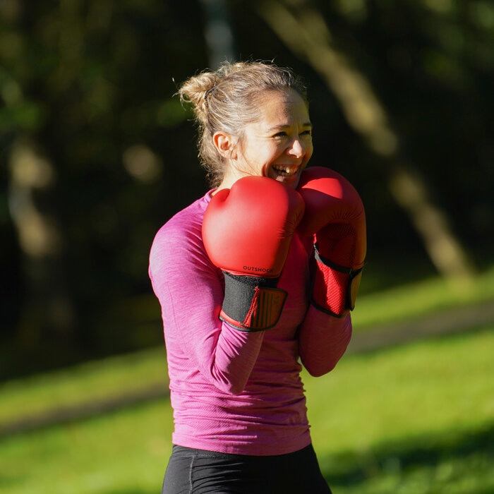 Une cliente d'ElieB Coaching souriante en plein air, pratiquant la boxe.